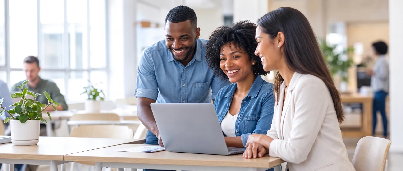 Three Velocity colleagues smiling at a laptop together